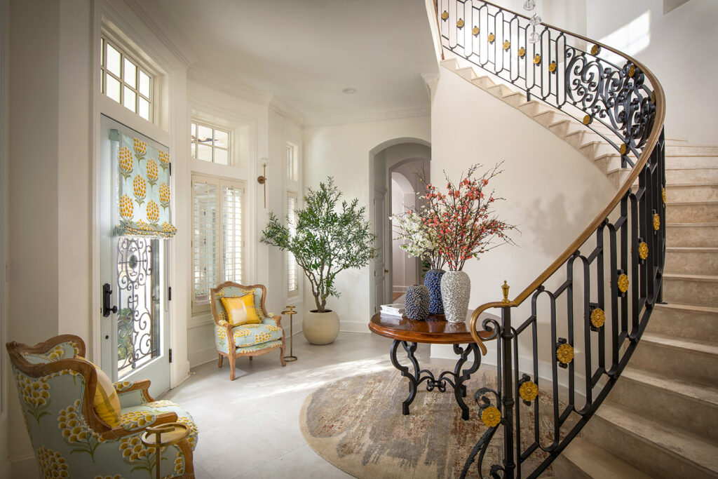 "Luxury Texas entry and staircase with neutral tones, custom furniture, and natural light"